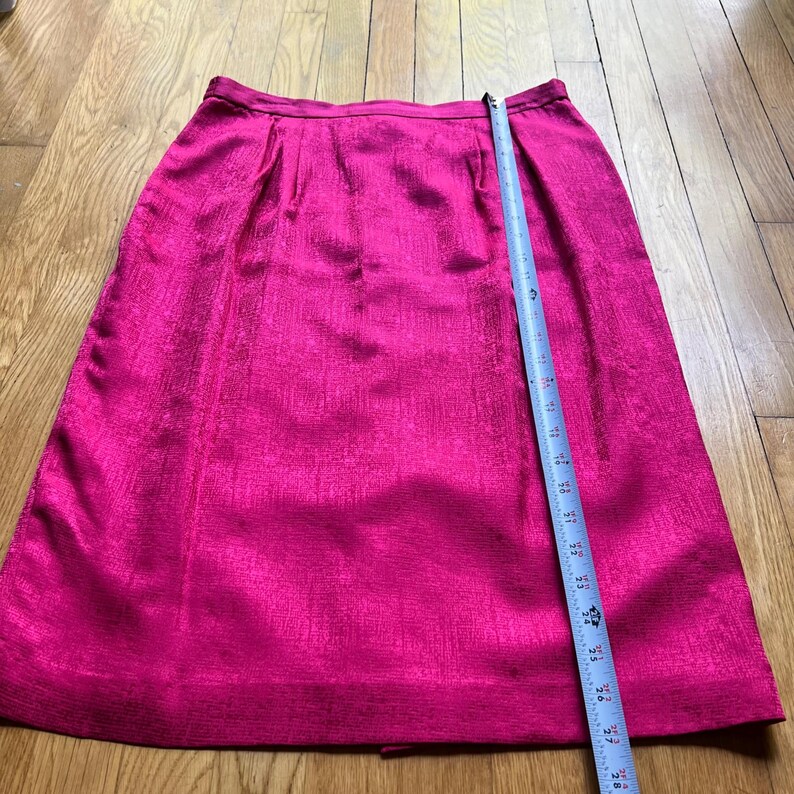 Peut inclure: Une jupe rose vif avec une surface textur&eacute;e. Un ruban &agrave; mesurer est pos&eacute; sur la jupe. La jupe mesure environ 76 cm de long.