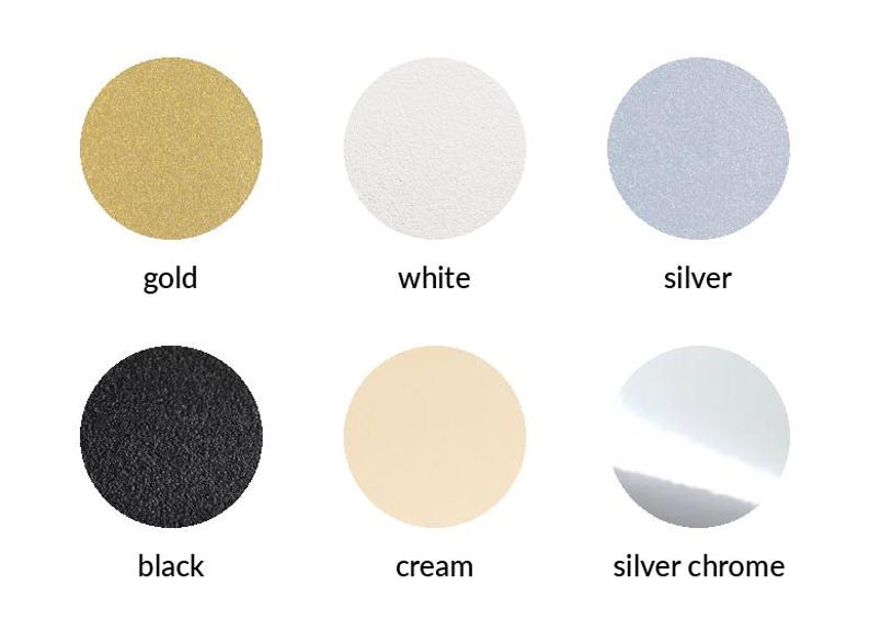May include: A color chart featuring six circular swatches arranged in two rows. The top row displays gold, white, and silver circles. The bottom row shows black, cream, and silver chrome circles, each labeled with its corresponding color name.