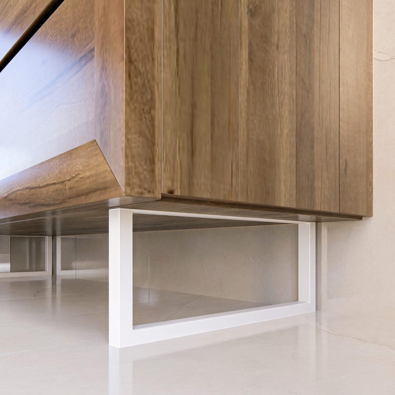 May include: A wooden cabinet with a visible natural grain pattern featuring a smooth, brown finish. The cabinet is supported by a rectangular, white metal base frame that provides a clean, structural contrast to the warm wood tones above.