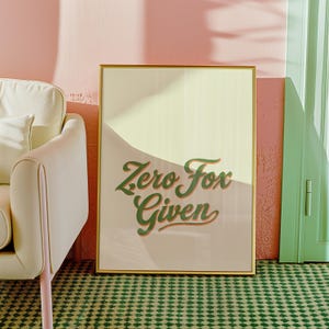 May include: A gold framed poster with a light yellow background and green text that reads "Zero Fox Given".