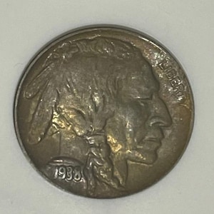 May include: A 1938-D/D Buffalo nickel graded AU55 by ANACS. The coin features a profile of a Native American on one side and a buffalo on the other. The coin is encased in a protective holder.