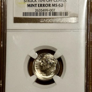 May include: A 1966 10C coin, graded MS 62, with a 10% off-center strike error, encased in a protective holder. The coin features a profile of a man and the word "LIBERTY". The holder has the NGC logo and serial number.