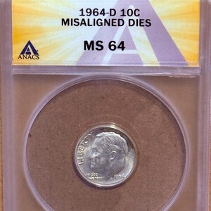 May include: A 1964-D 10C MS 64 coin in a protective case. The coin features the text "LIBERTY" and the year "1964". The case has text that reads "1964-D 10C MS 64" and "MISALIGNED DIES".