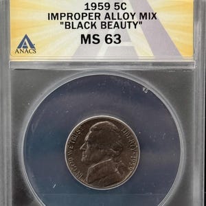 May include: A 1959 5C "Black Beauty" nickel coin, encapsulated in a protective case. The coin features a profile of Thomas Jefferson and the text "In God We Trust" and "Liberty". The case has a label with the text "1959 5C MS 63".