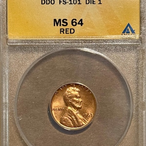 May include: A 1963-D 1C MS 64 Red Lincoln cent coin encased in a clear holder. The coin is copper-colored with the text "IN GOD WE TRUST" and "LIBERTY" visible. The holder has text that reads "1963-D 1C MS 64 RED".