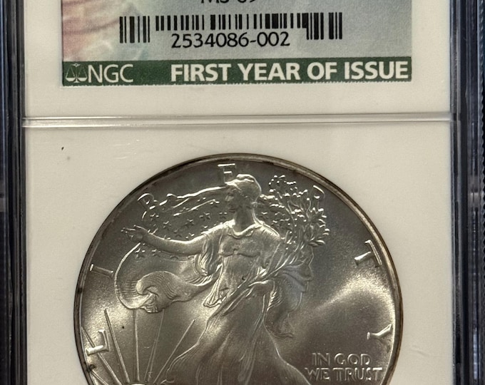 1986 P American Silver Eagle ASE • Key Date • Philadelphia Mint • First Year of Issue Label • Light Rim Tarnishing • Graded NGC MS69