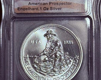 1985 Engelhard American Prospector Vintage Silver Round • 1 oz Fine Silver (99.9% Pure) • Flag Label • Eagle Reverse • Graded ICG MS69