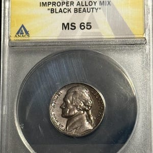 May include: A 1958 5C "Black Beauty" nickel coin, graded MS 65, encased in a clear protective holder. The coin features a profile of Thomas Jefferson. The holder has a yellow and white label with the coin's details and the ANACS logo.