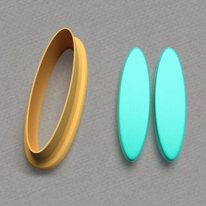 Puede incluir: Dos cortadores de galletas ovalados de color turquesa y un cortador de galletas ovalado de color dorado.