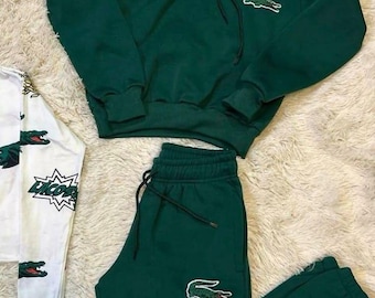 Conjunto deportivo Lacoste verde con sudadera con capucha y pantalones deportivos, logo de cocodrilo, ropa urbana informal para hombre y mujer. Conjunto a juego.