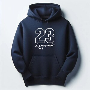 May include: Navy blue hoodie with a front pocket and a hood. The hoodie features the number "23" in a white, outlined font, with the word "Legend" written below in a cursive font.