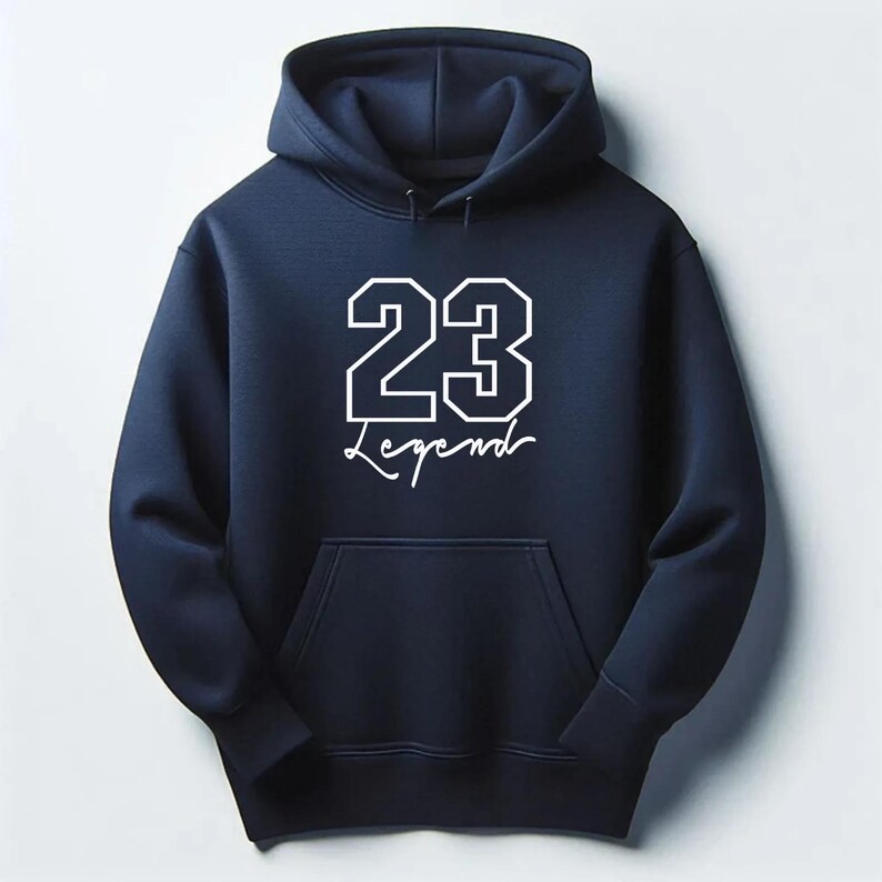 May include: Navy blue hoodie with a front pocket and a hood. The hoodie features the number "23" in a white, outlined font, with the word "Legend" written below in a cursive font.
