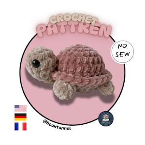 May include: A plush crochet turtle made of soft, light brown and dusty rose yarn with black plastic eyes. The image features the text CROCHET PATTREN and NO SEW, along with the handle @booktunnel and small flag icons for the USA, Germany, and France.