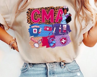 May include: A beige t-shirt with a pink "CMA" graphic. The graphic features a cartoon nurse with a leopard print background and medical supplies.