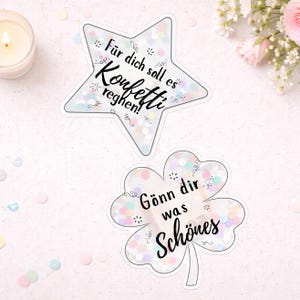 May include: Two stickers: a star and a four-leaf clover. The star-shaped sticker has the text "F&uuml;r dich soll es Konfetti regnen!" The clover-shaped sticker has the text "G&ouml;nn dir was Sch&ouml;nes". Both stickers have a confetti design.