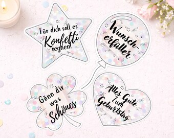 May include: Four decorative stickers with a pastel confetti pattern. Shapes include a star with text 'Für dich soll es Konfetti regnen!', a balloon with 'Wunsch-erfüller', a four-leaf clover with 'Gönn dir was Schönes', and a heart with 'Alles Gute zum Geburtstag'.