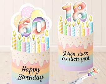 May include: Two birthday cake decorations. One displays the number 60 with candles and the words "Happy Birthday." The other shows the number 18 with candles and the German phrase "Schön, dass es dich gibt."