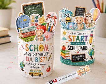 Könnte beinhalten: Zwei zylindrische Behälter mit Illustrationen zum Thema Schule, darunter ein gelber Bus, Bücher und Globen. Der Text lautet "SCHÖN, DASS DU WIEDER DA BIST!" und "EIN TOLLER START IN EIN NEUES SCHULJAHR!" mit einem kleinen Schokoriegel mit der Aufschrift "du".