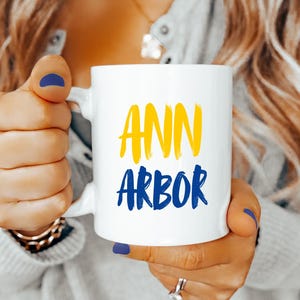Ann Arbor Coffee Mug Michigan Blue Yellow Brush Font Ceramic Cup College Town Gift for Wolverines Fans Students Alumni Game Day Pride