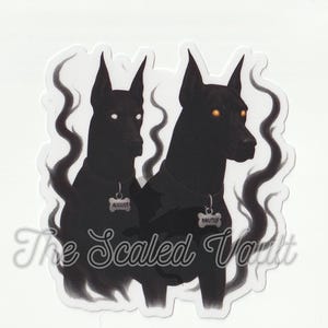 Peut inclure: Autocollant repr&eacute;sentant deux chiens noirs aux yeux brillants. Chaque chien porte une &eacute;tiquette avec un nom : "August" et "Brutus". Les chiens sont plac&eacute;s sur un fond blanc avec des accents tourbillonnants et enfum&eacute;s. Le texte "The Scaled Vault" est en bas.