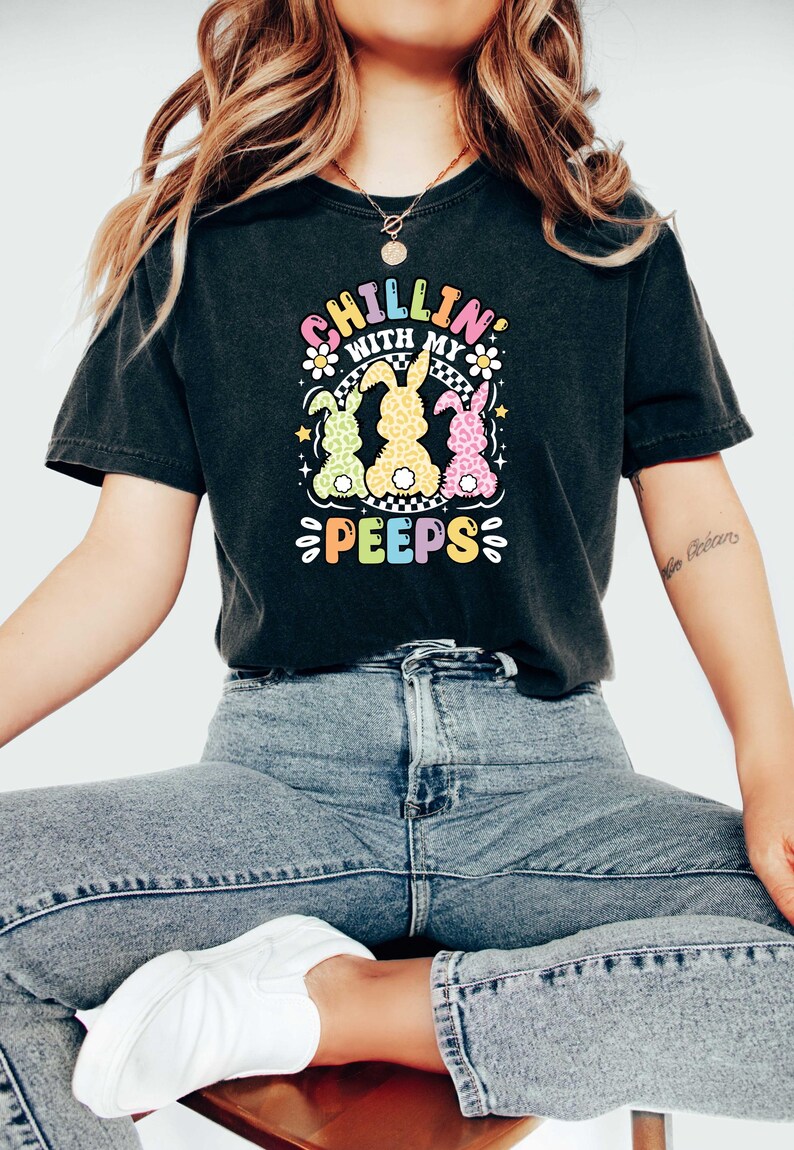 May include: A black t-shirt with a graphic of three colorful cartoon bunnies and the text "Chillin' with my peeps".