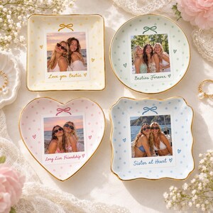 May include: Four ceramic trinket dishes with gold-trimmed edges, each featuring a custom photo print of two people, a small bow graphic, and text including Love you Bestie, Besties Forever, Long Live Friendship, and Sister at Heart.