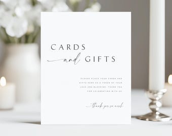 May include: A white card with the words "CARDS and GIFTS" in elegant black script. Below, the text reads "PLEASE PLACE YOUR CARDS AND GIFTS HERE AS A TOKEN OF YOUR LOVE AND BLESSING. THANK YOU FOR CELEBRATING WITH US. Thank you so much."
