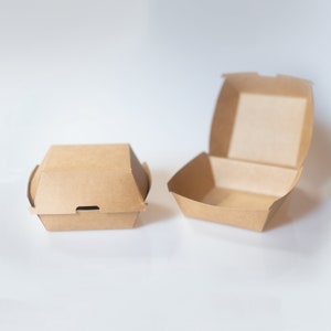 May include: Two brown cardboard boxes for takeout food. One box is closed and the other is open.