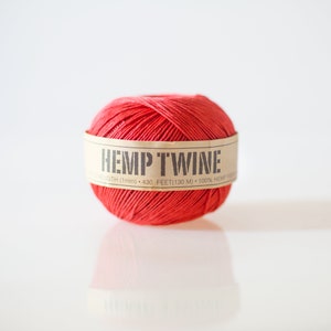 May include: A ball of red hemp twine with a brown label that reads "HEMP TWINE STRENGTH (1mm) 430 FEET (130 M) 100% HEMP FIBRE"