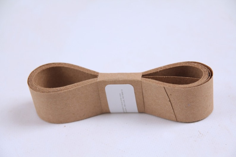 May include: A roll of brown paper tape, folded in half and tied with a white label. The label has the text "FURNITURE, APPLIANCE and CARPET PROTECTION" printed on it.