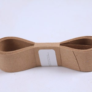 May include: A roll of brown paper tape, folded in half and tied with a white label. The label has the text "FURNITURE, APPLIANCE and CARPET PROTECTION" printed on it.