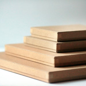 May include: Four brown cardboard boxes stacked on top of each other. The boxes are all the same size and shape, and they are all made of a plain brown cardboard.