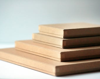 May include: Four brown cardboard boxes stacked on top of each other. The boxes are all the same size and shape, and they are all made of a plain brown cardboard.