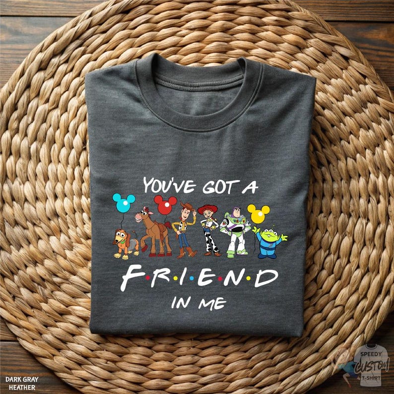 A gray t-shirt with a graphic design featuring characters from the TV show "Friends" and the text "You've Got a Friend in Me".