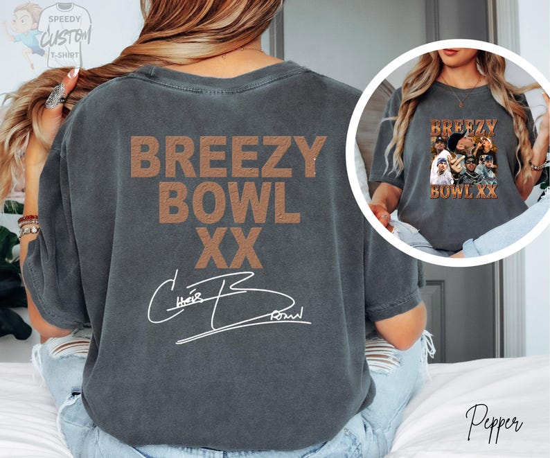 a person wearing a grey t-shirt with the text "BREEZY BOWL XX" printed on it.