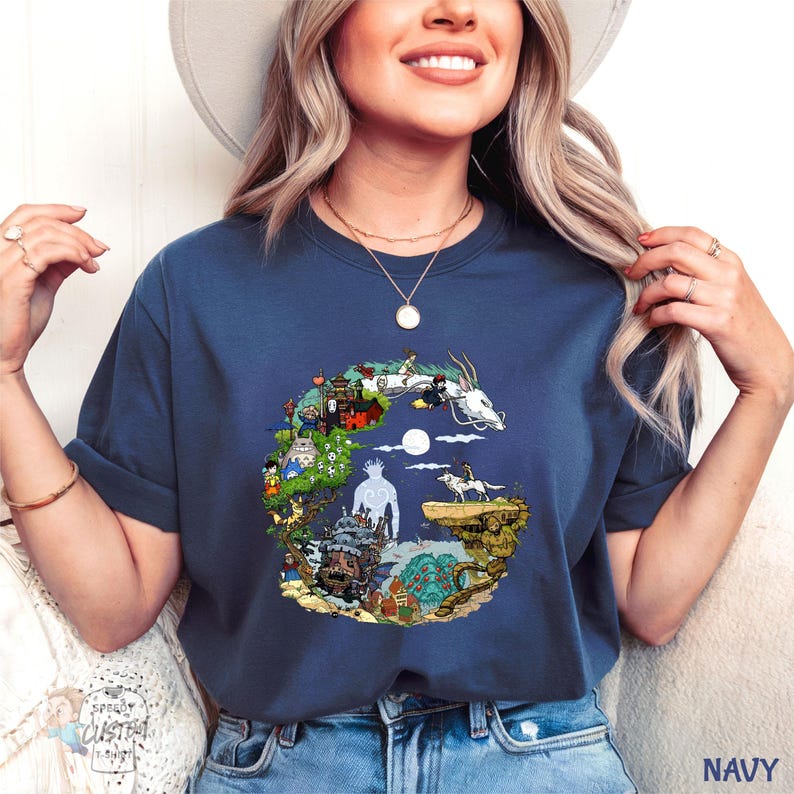 A woman wearing a navy blue t-shirt with a graphic design of a castle and a dragon, smiling and posing for the camera.