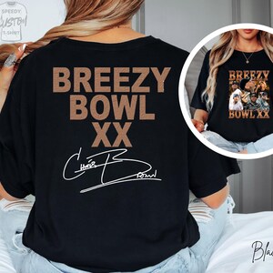 a person wearing a black t-shirt with the text "BREEZY BOWL XXX" printed on it.