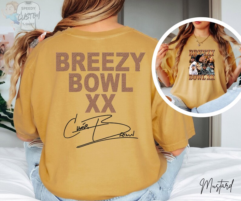 a person wearing a yellow t-shirt with the text "BREEZY BOWL XXX" printed on it.