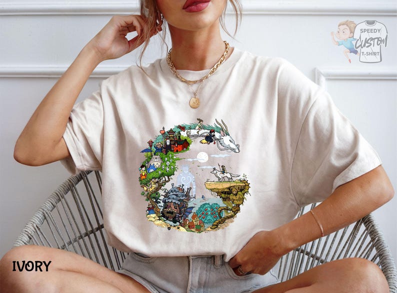 A woman wearing a white t-shirt with a colorful graphic design depicting a castle, a unicorn, and various other elements.