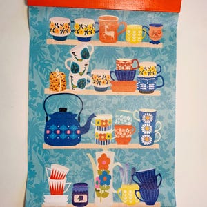 May include: A colorful print of a kitchen shelf with a variety of mugs, teacups, and a blue teapot with a geometric pattern. The shelf is against a light blue background with a floral pattern.