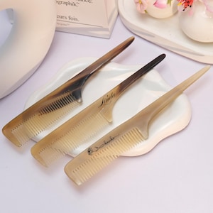 May include: A white ceramic mug with a black handle and the text "But First, Coffee" in a black, bold font. The mug is on a white surface.