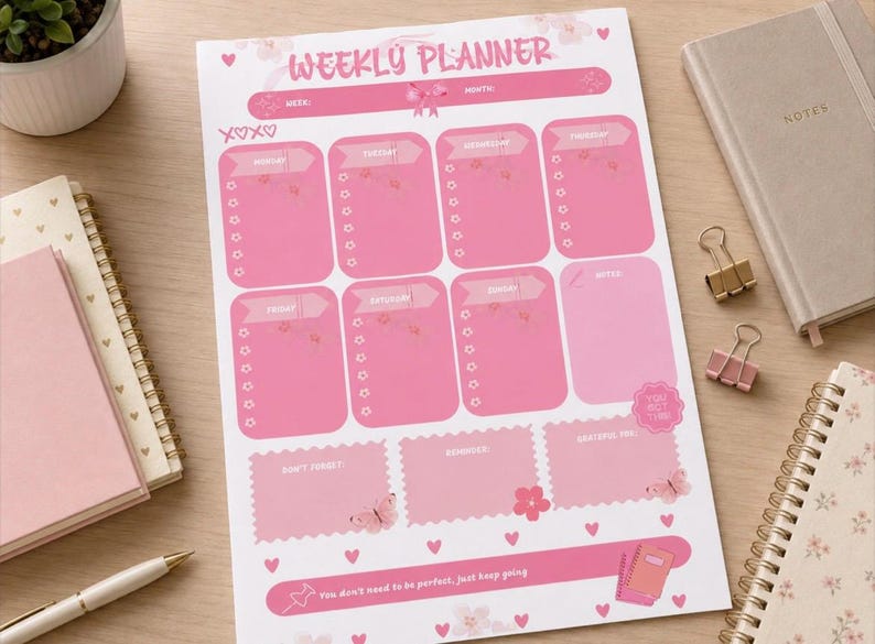 May include: A white weekly planner sheet with pink accents, featuring the text WEEKLY PLANNER at the top. The layout includes sections for each day of the week, a notes section, and boxes labeled DON'T FORGET, REMINDERS, and GRATEFUL FOR, with butterfly graphics.