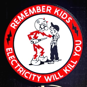 Puede incluir: Un letrero circular con borde rojo y centro blanco que presenta un personaje de dibujos animados hecho de rayos rojos sosteniendo un cuchillo cerca de un niño. El texto REMEMBER KIDS ELECTRICITY WILL KILL YOU está impreso en blanco en el borde rojo con iconos de rayos negros.