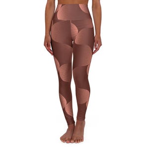 May include: High-waisted leggings in a brown and peach color scheme. The leggings feature a repeating pattern of large, overlapping circles. The fabric appears to have a textured, dotted surface. The leggings are form-fitting and reach the ankles.