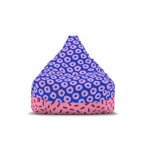 Puede incluir: Un puf azul con un patrón rosa de círculos y una base rosa con formas rectangulares rojas. Este puf es una opción de asiento cómoda para una sala de estar o un dormitorio.
