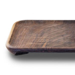 Peut inclure: Un plateau rectangulaire en bois brun foncé avec des coins arrondis et une surface texturée. Le plateau présente un bassin peu profond et est soutenu par de petits pieds intégrés à chaque coin, révélant un motif de grain de bois naturel.