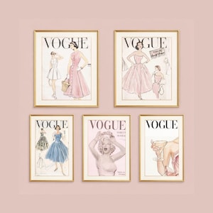 May include: Five framed Vogue magazine covers. The covers feature illustrations of women in dresses, including a pink dress and a blue dress. One cover features Marilyn Monroe. The frames have gold-colored borders.