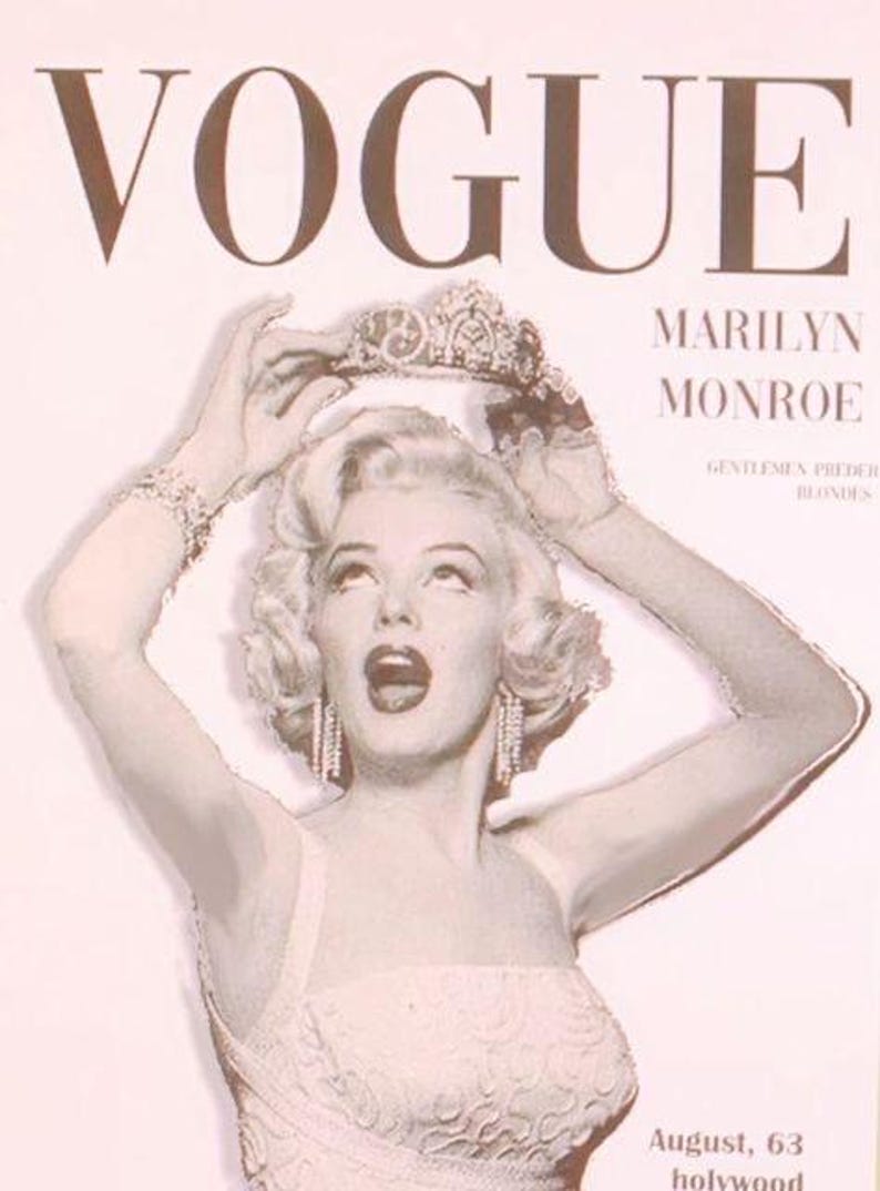 May include: Vogue magazine cover featuring Marilyn Monroe. The cover has a sepia tone with the word "VOGUE" at the top. Monroe is wearing a crown and jewelry. The text "MARILYN MONROE" is below the Vogue logo. The text "August, 63 hollywood" is at the bottom.