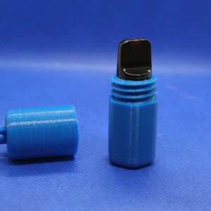 Könnte beinhalten: Ein blauer Plastikbehälter mit schwarzem Deckel und einem passenden blauen Deckel. Der Behälter hat eine kleine Schlaufe an der Seite.