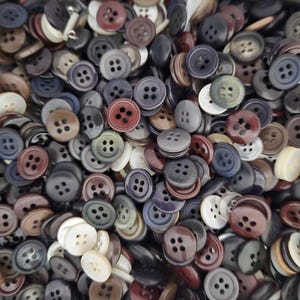 May include: A large assortment of buttons in various colors and sizes. The buttons are made of plastic and have a smooth finish. They are perfect for sewing projects or crafts.